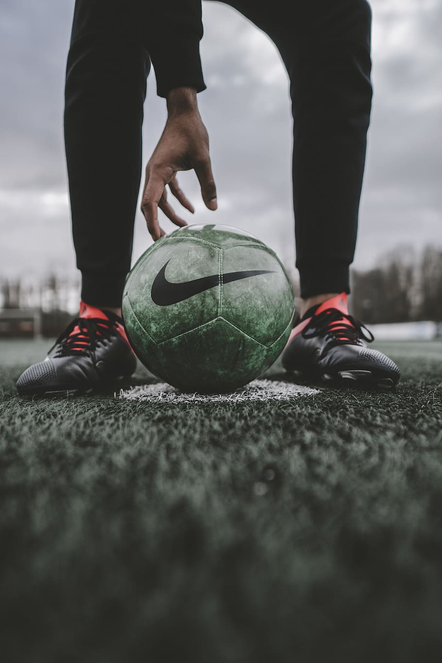 person standing in front of Nike soccer ball, footwear, shoe