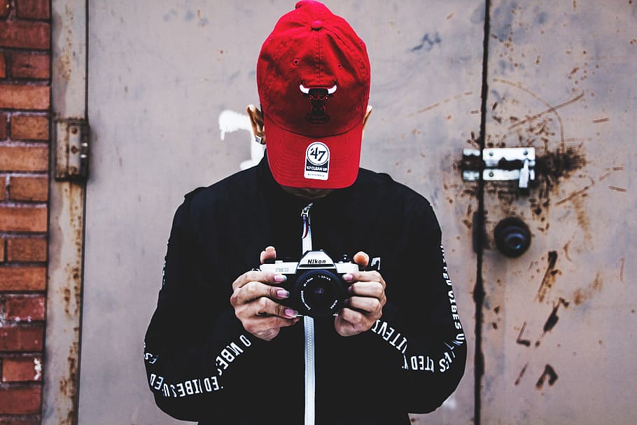 Photo of Person Holding Camera, black jacket, camera lens, cap HD wallpaper