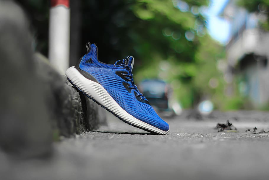 selective focus photography of unpaired blue and white adidas running shoe leaning on concrete pavement at daytime, HD wallpaper