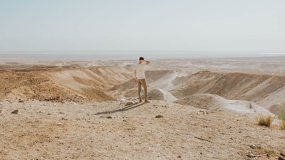 man standing at the desert during day, soil, sand, nature, outdoors
