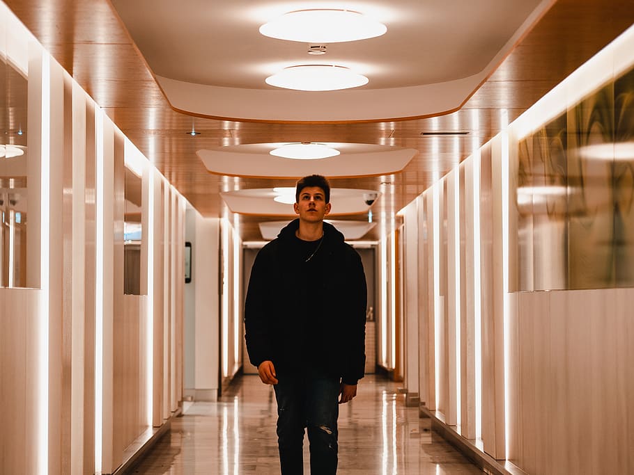 man standing indoor, corridor, flooring, human, person, lighting HD wallpaper