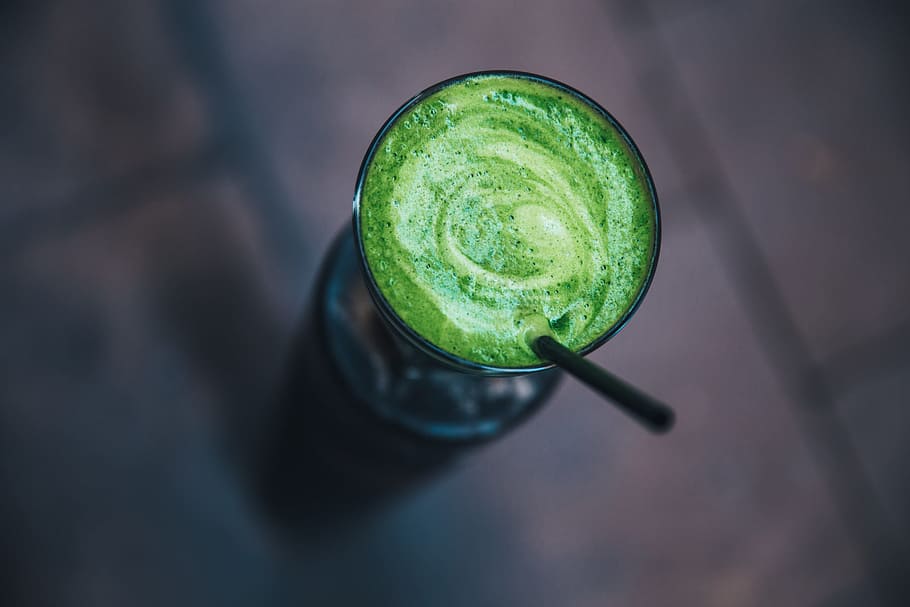 Green health smoothie served in a glass with straw, beverage