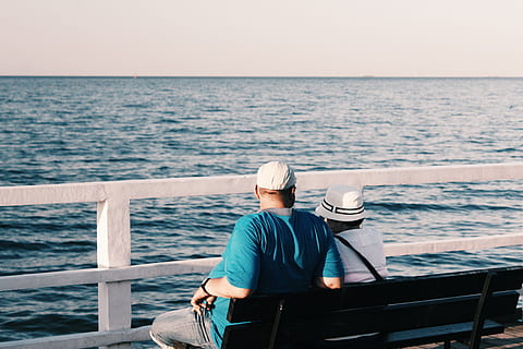 Man in Blue Shirt Beside Woman in White Shirt Sitting on Bench HD wallpaper