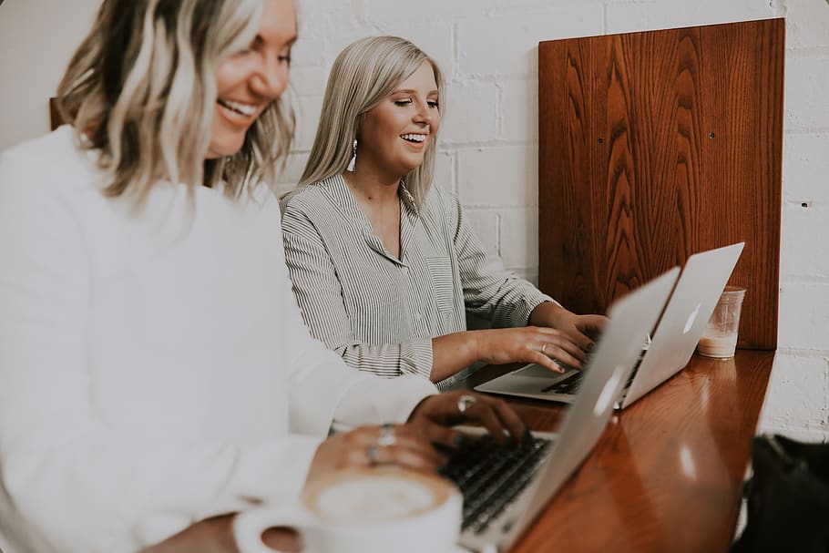 two women using laptops, smiling, computer, communication, wireless technology HD wallpaper