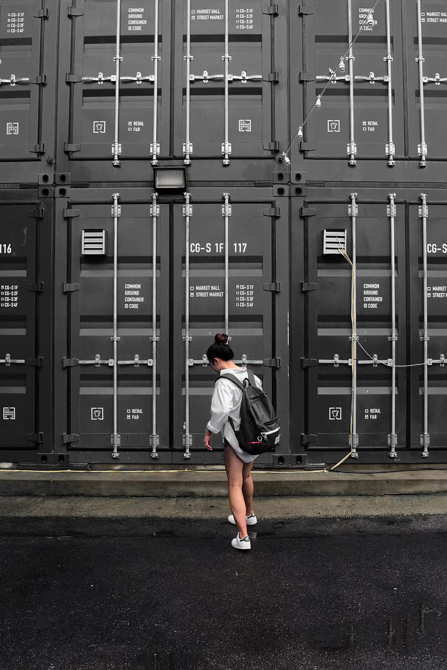 Photography of Woman in Gray Long Sleeve Shirt Carrying Black Backpack Standing in Front of Black Intermodal Container HD wallpaper