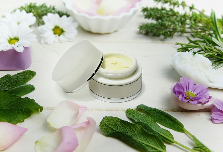 Cream with botanical ingredients surrounding the jar., skin, care