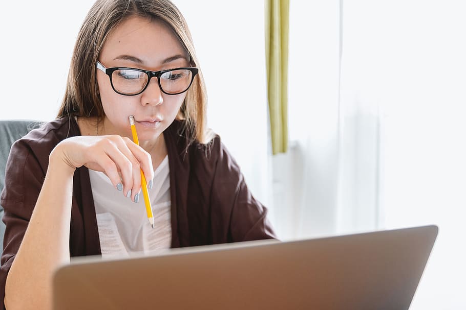 Young woman think and looking on the laptop, eyeglasses, one person HD wallpaper