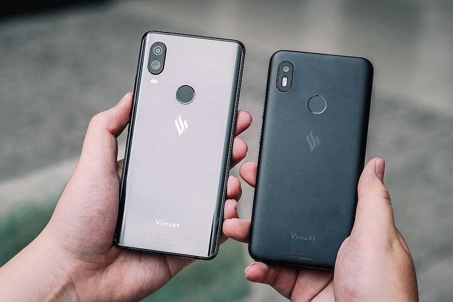 two black and gray Android smartphones, human hand, wireless technology HD wallpaper