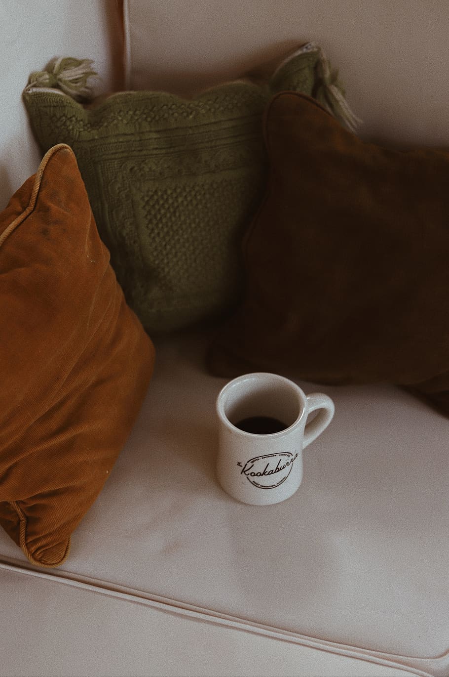 white ceramic mug near three assorted-color throw pillows, cup HD wallpaper