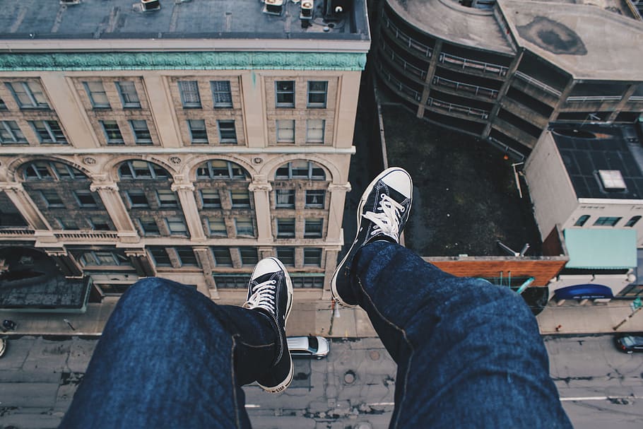 person sitting on cliff above building, low section, one person HD wallpaper