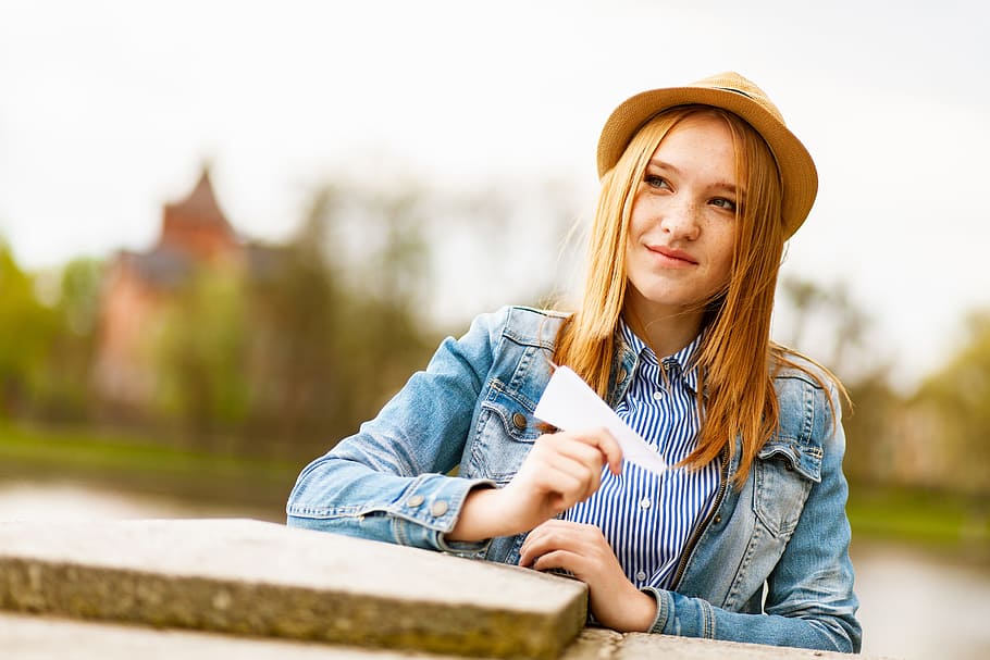 Selective Focus Photo of Woman Smiling Holding White Paper Airplane HD wallpaper
