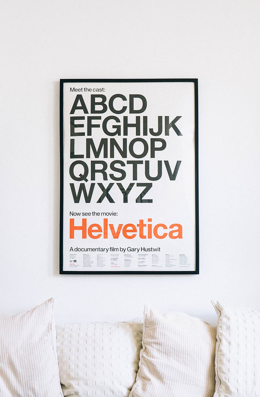 wall mounted Helvetica alphabet poster above sofa, text, western script