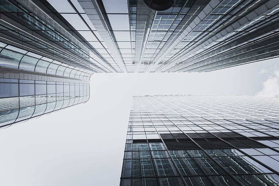 low-angle photography of two high rise curtain wall buildings under white clouds at daytime HD wallpaper