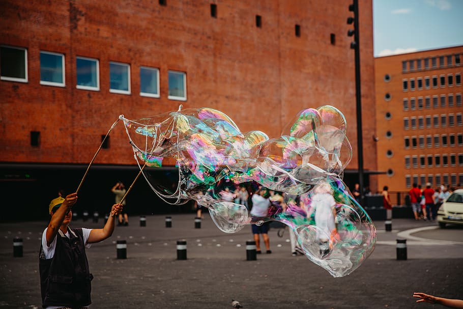 man doing bubble stunts at daytime, architecture, bubble wand HD wallpaper
