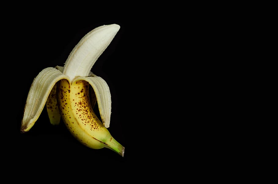 ripe banana peeled off, studio shot, black background, healthy eating