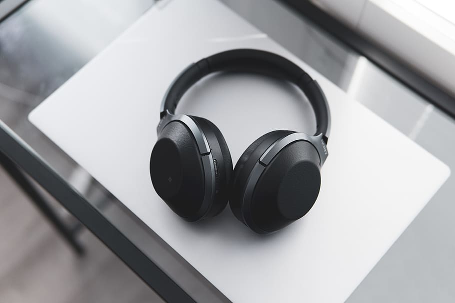 gray and black wireless headphones on desk, headset, electronics