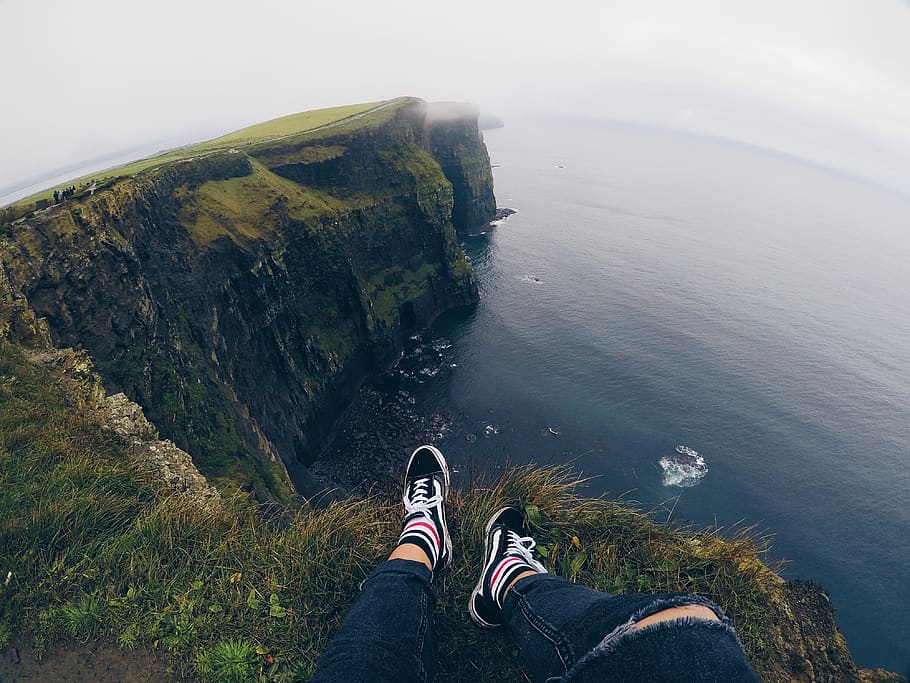 person sitting on cliff under white sky, apparel, clothing, shoe, HD wallpaper
