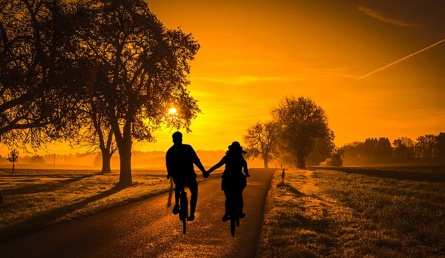 Photo illustration of couple on a bicycle in evening country landscape