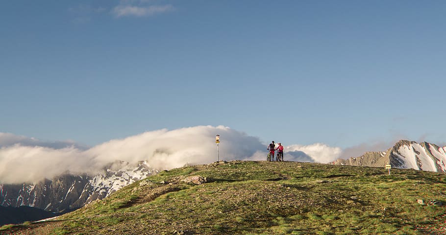 Two Man Standing on Mountain Near Mountain Covered by Snows, clouds HD wallpaper