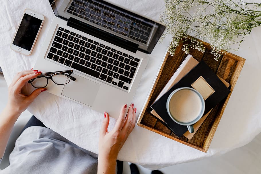 A woman works at a desk with a laptop and a cup of coffee, macbook, HD wallpaper