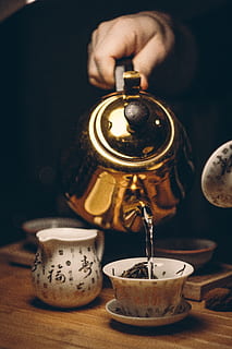 Person Holding Gold Teapot Pouring White Ceramic Teacup, beverage HD wallpaper