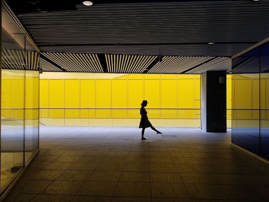 woman standing inside building, person, interior, shadow, yellow HD wallpaper