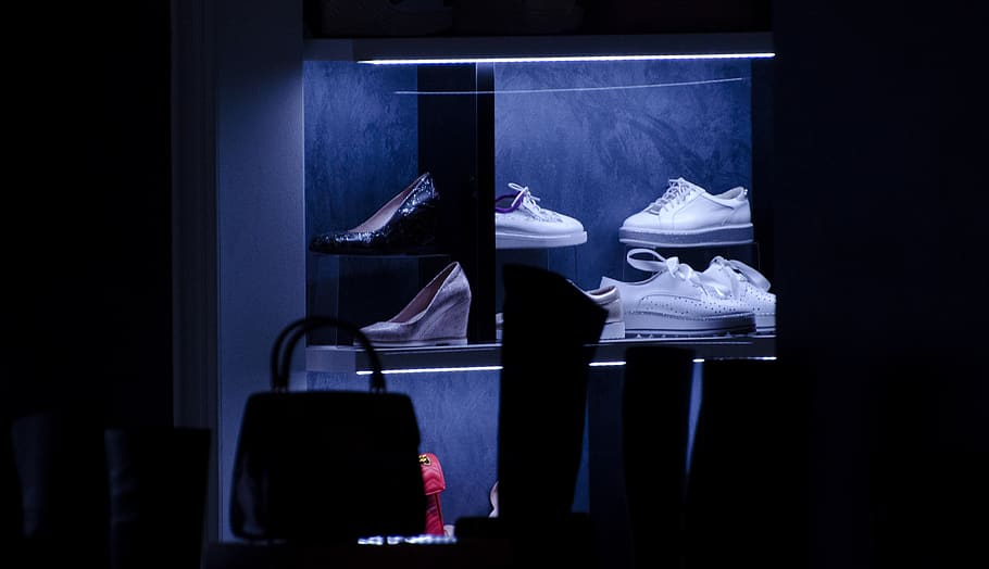 lit shoe display collection inside a dark room, clothing, apparel