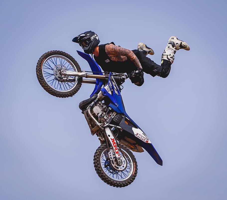 rider with blue dirt bike soaring on air, motorcycle, helmet