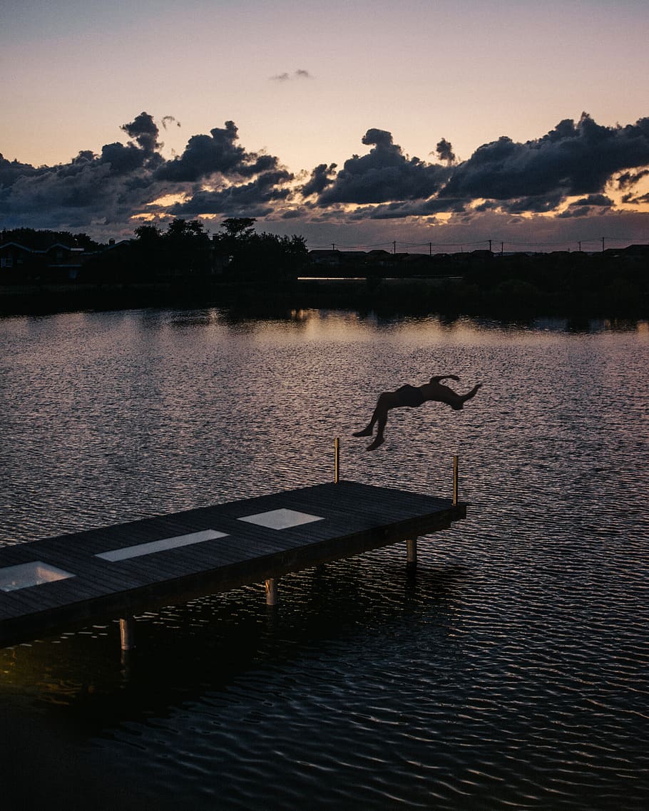 Silhouette Of Person Back Flipping On Body Of Water, backlit HD wallpaper