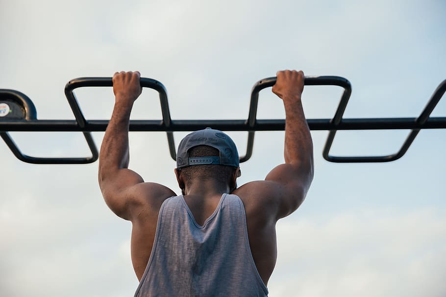 A young african man doing chin-up exercise in outdoors, 25-30 year old