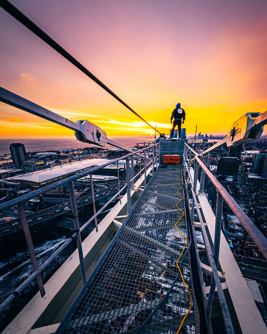 man standing on gray bridge, sky, sunset, orange color, architecture HD wallpaper