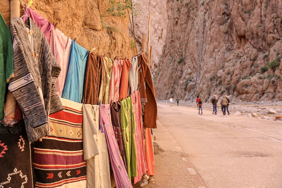 assorted clothes beside rock cliff, hanging, day, clothing, retail HD wallpaper