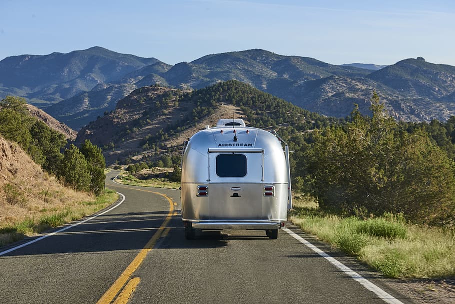 grey and brown vehicle running on the road during daytime, airstream silver bullet