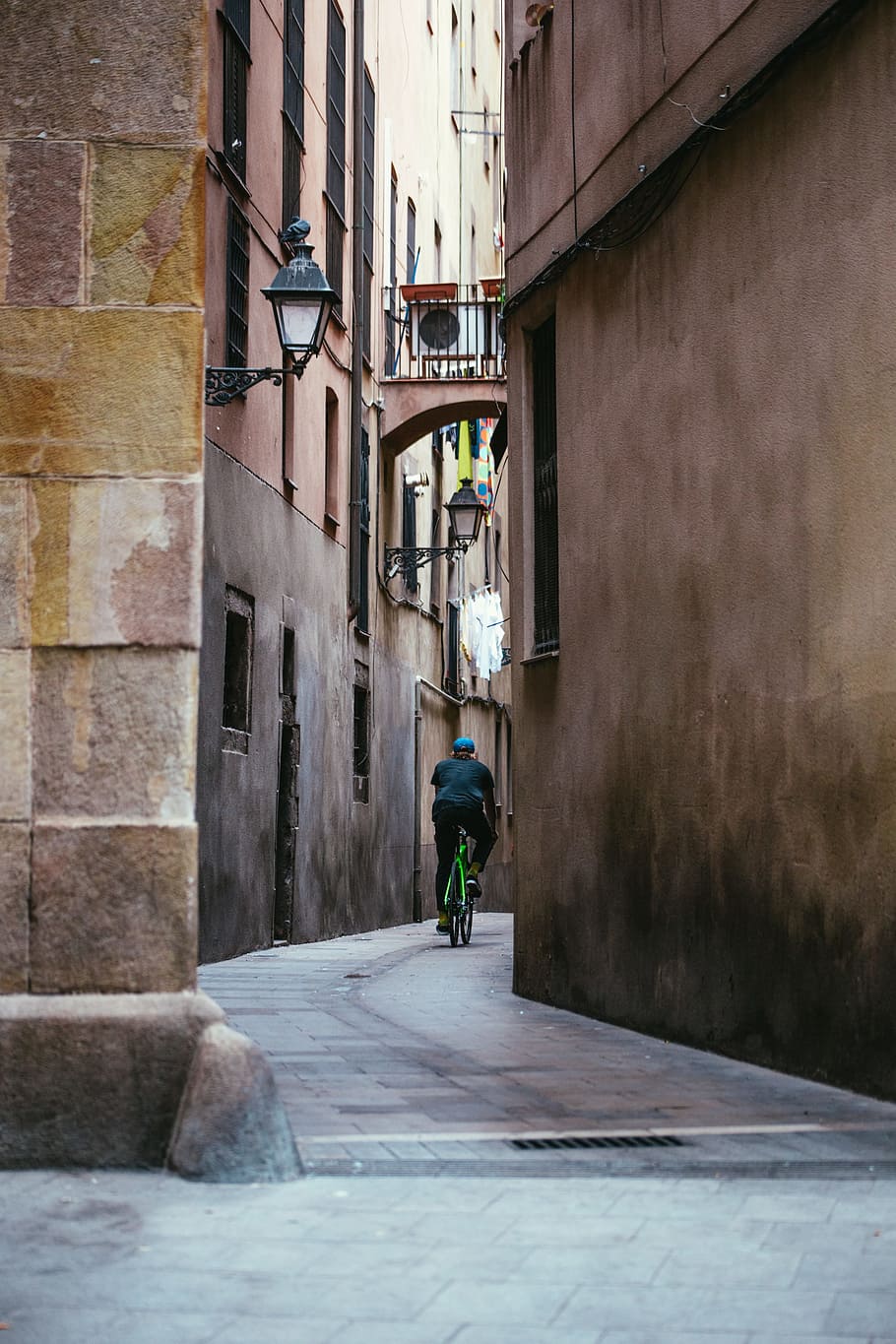 A young cyclist riding his bicycle in a narrow street, Architecture