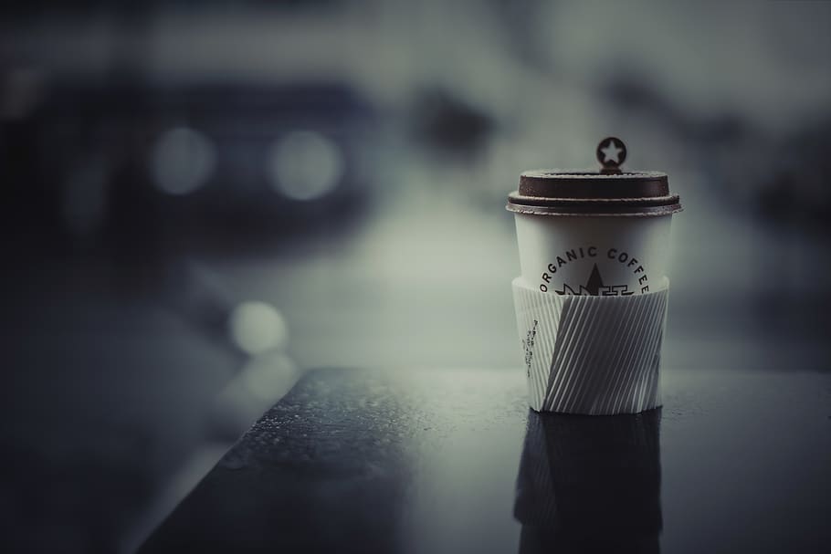white and brown disposable cup on black table, london, united kingdom