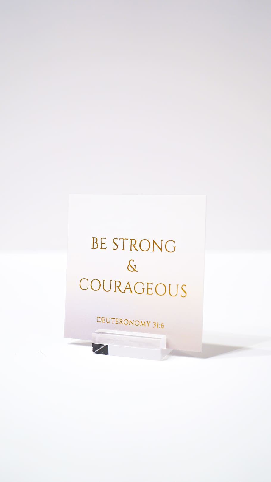 white paper with be strong and courageous printed text, studio shot