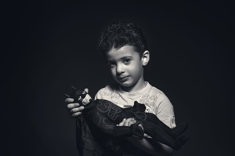 Grayscale Photo of a boy Holding Batman Plush Toy, black-and-white