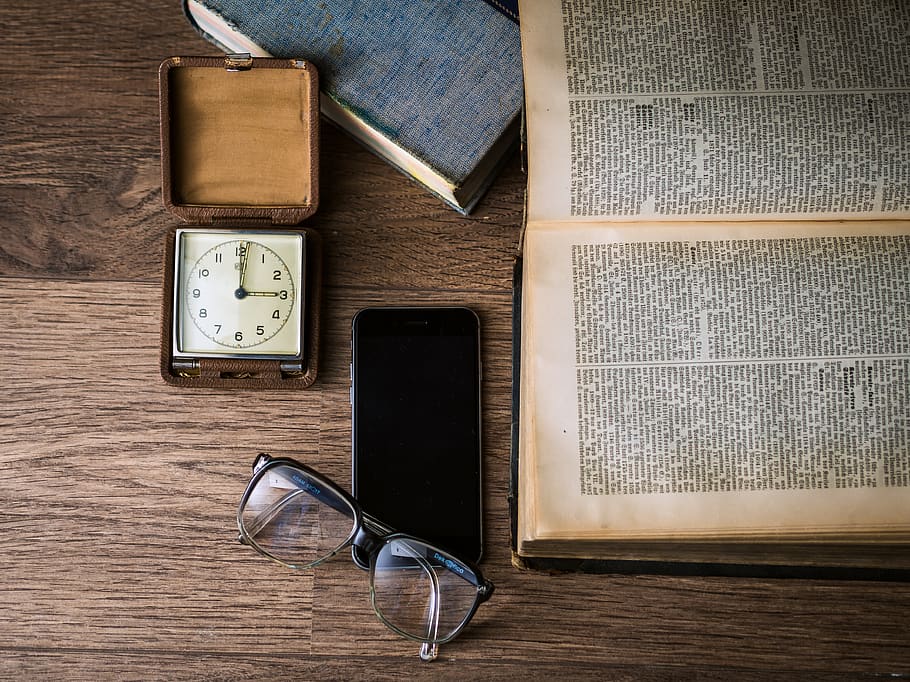 Black Framed Eyeglasses on Top of Black Smartphone Near Brown Square Analog Clock on Brown Wooden Surface HD wallpaper