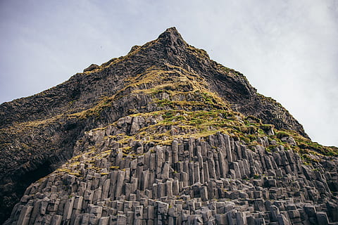 Basalt columns in Iceland with layered rock formations, clouds HD wallpaper