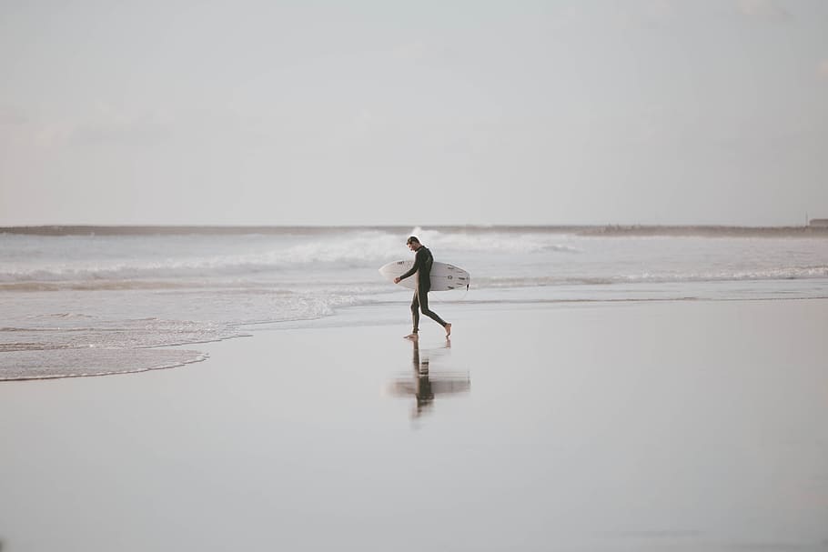 man holding surfboard walking in the beach during daytime, wafe HD wallpaper