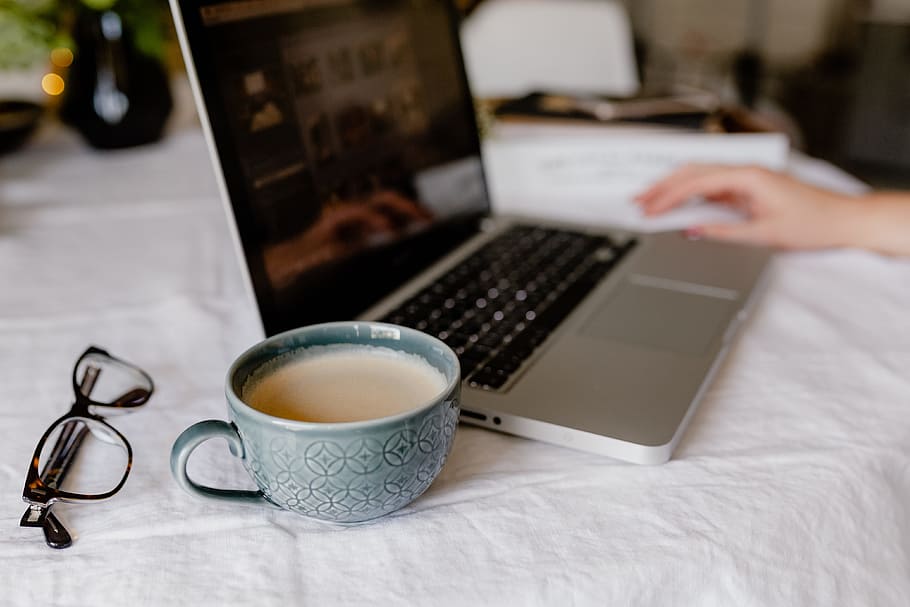 A woman works at a desk with a laptop and a cup of coffee, macbook HD wallpaper