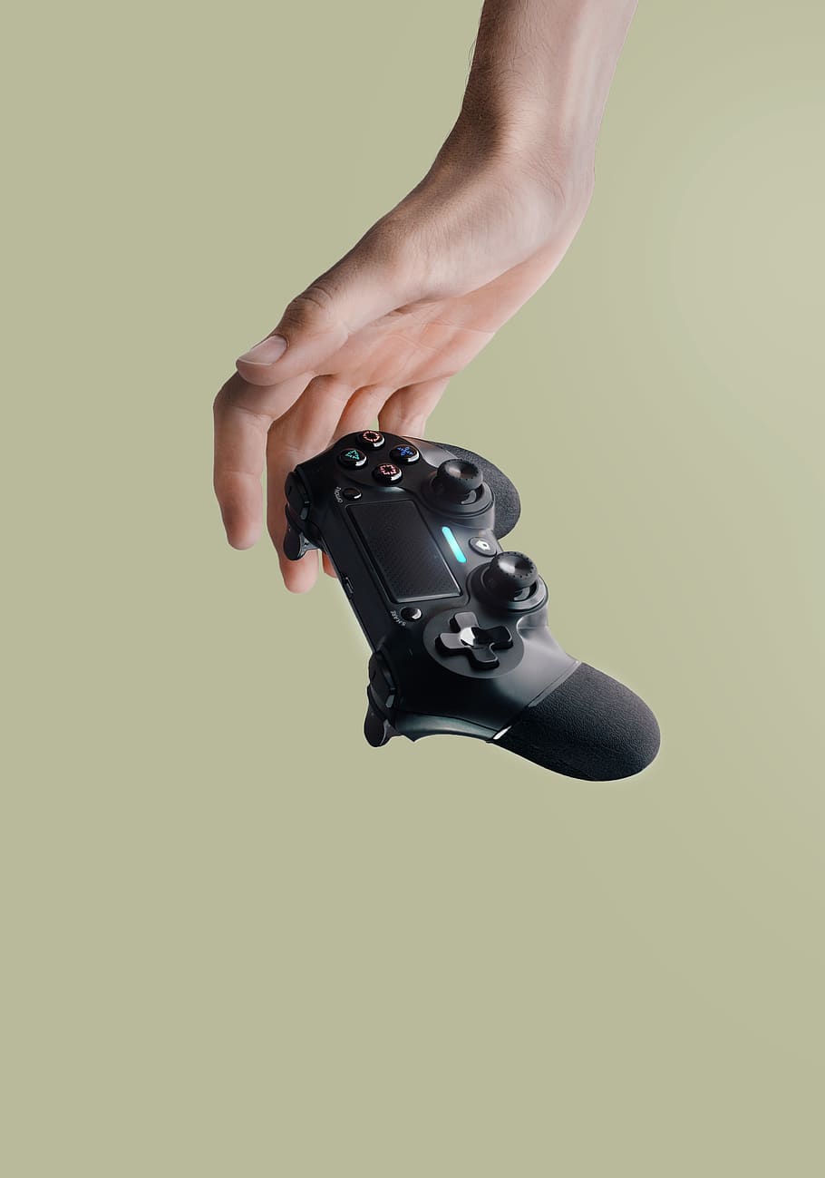 person holding Sony DualShock 4 wireless controller, human hand