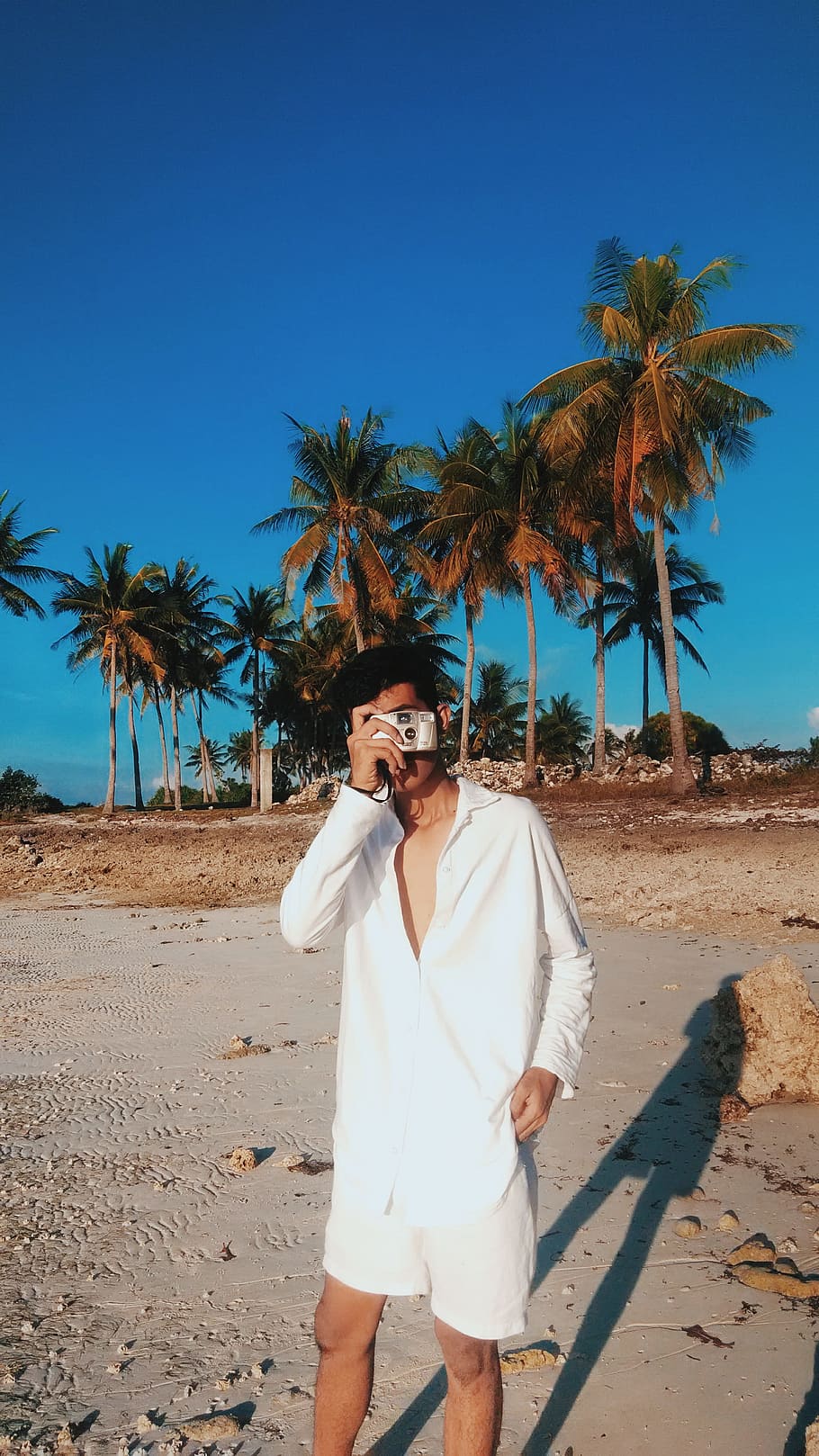 Man Wearing White Dress Shirt With White Shorts Holding Gray Camera HD wallpaper