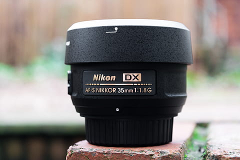 black Nikon lens, camera lens, electronics, wristwatch, mailbox HD wallpaper