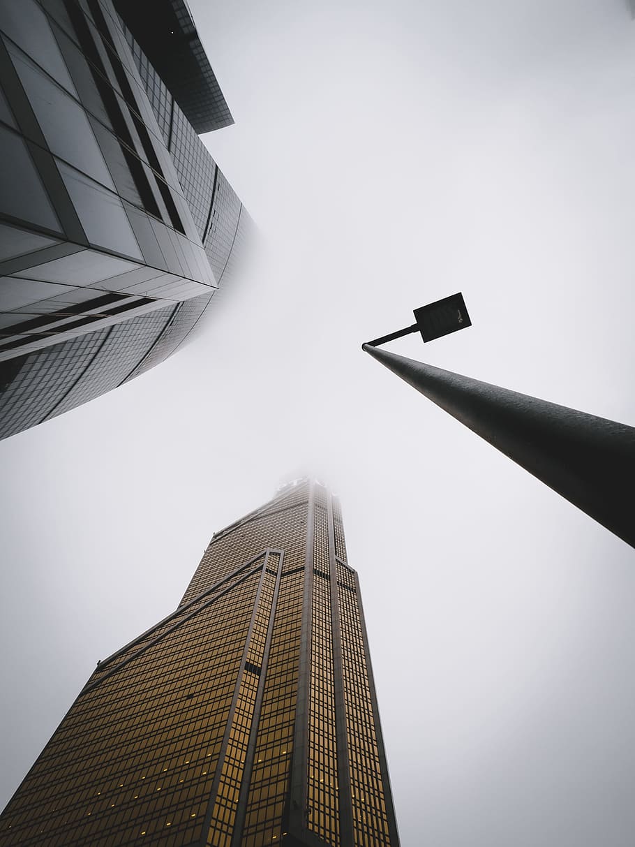 street light near city buildings under gray sky during daytime HD wallpaper