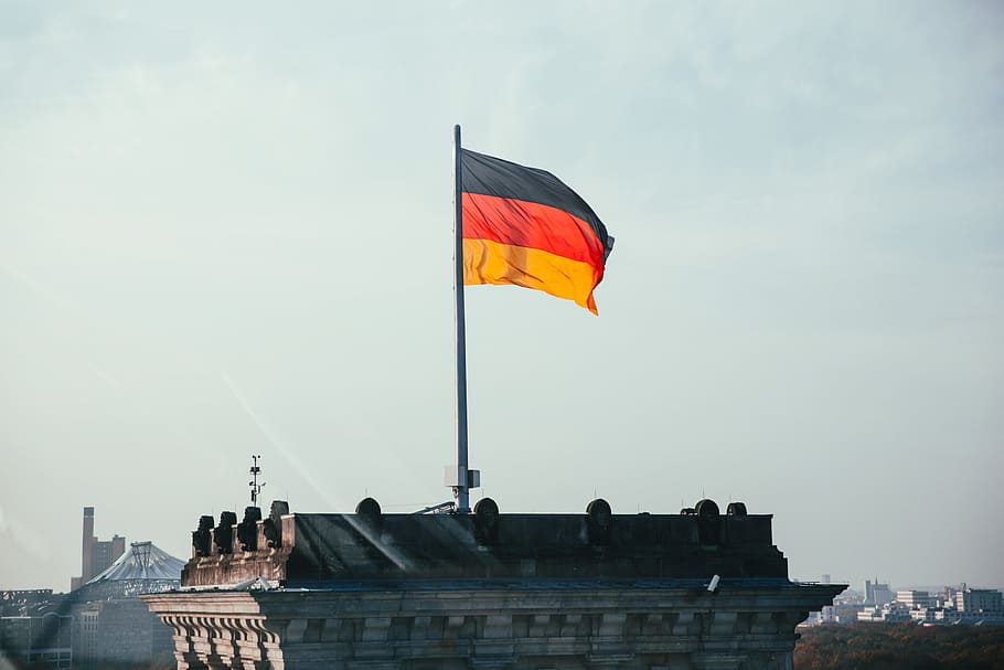 German flag fluttering on a rooftop in sunshine, architecture