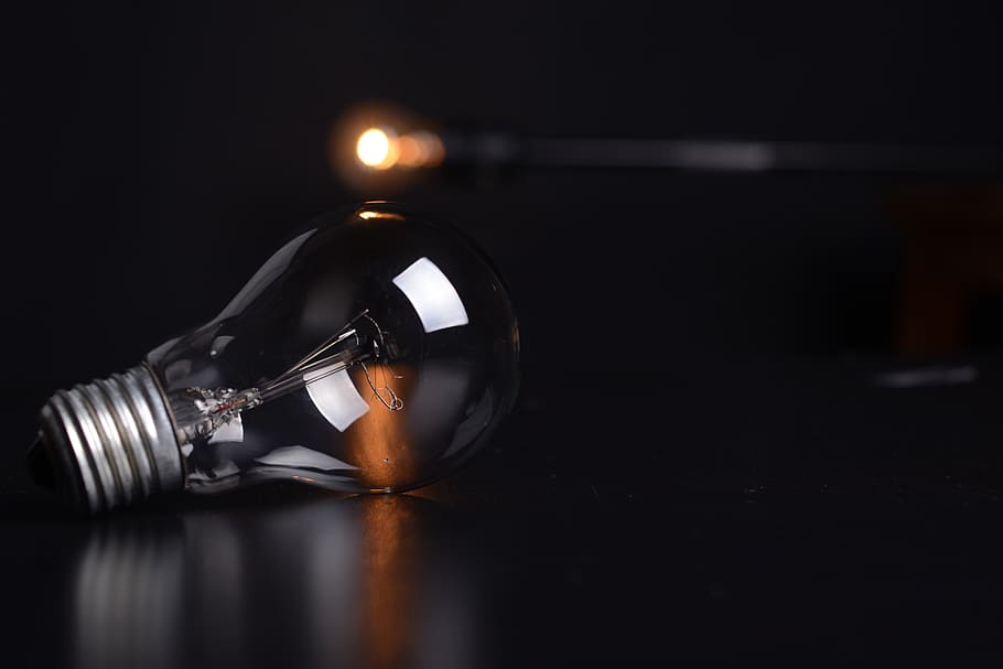 Clear Filament Bulb on Black Pad, action, blur, dark, electricity HD wallpaper