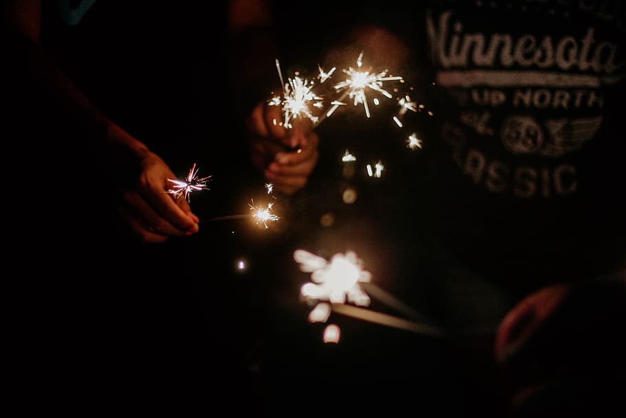 person holding fireworks, sparkler, light, hand, celebrate, party HD wallpaper
