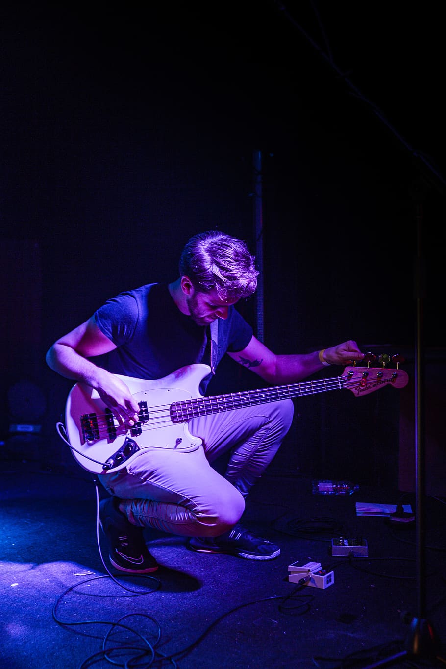 Man Tuning His Bass Guitar on Stage, electric guitar, guitarist