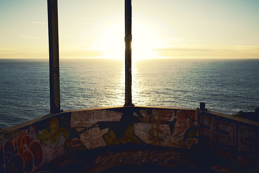 Ocean, graffiti, bunker, explode, explosion, sun, clouds, sunset HD wallpaper